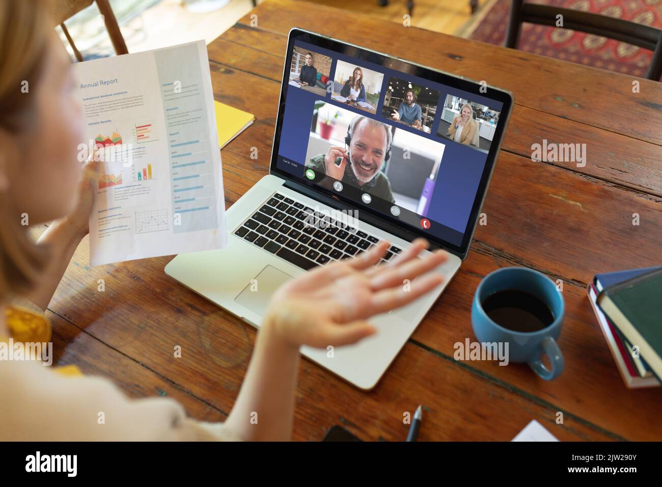Colleghi multirazziali durante una riunione online con la donna d'affari caucasica in possesso di dati Foto Stock