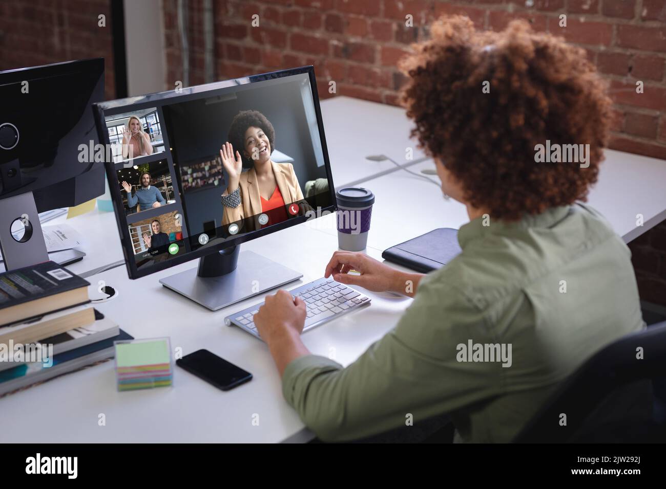 Un imprenditore biracial afro che partecipa a un incontro online con colleghi multirazziali tramite pc desktop Foto Stock