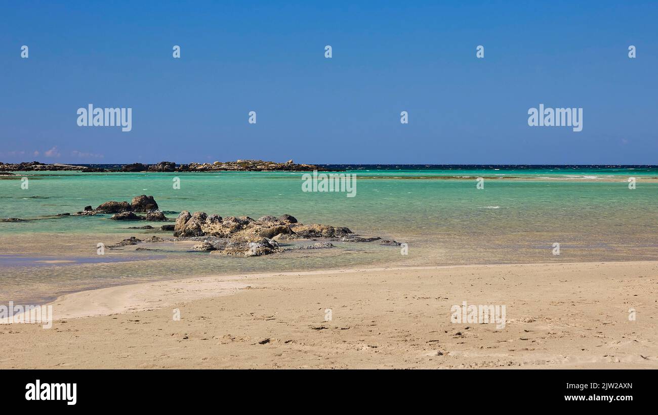 Cielo blu quasi senza nuvole, turchese del mare, verde mare, rocce nel mare, spiaggia sabbiosa, spiaggia di Elafonissi, Creta sud-occidentale, Isola di Creta, Greco Foto Stock