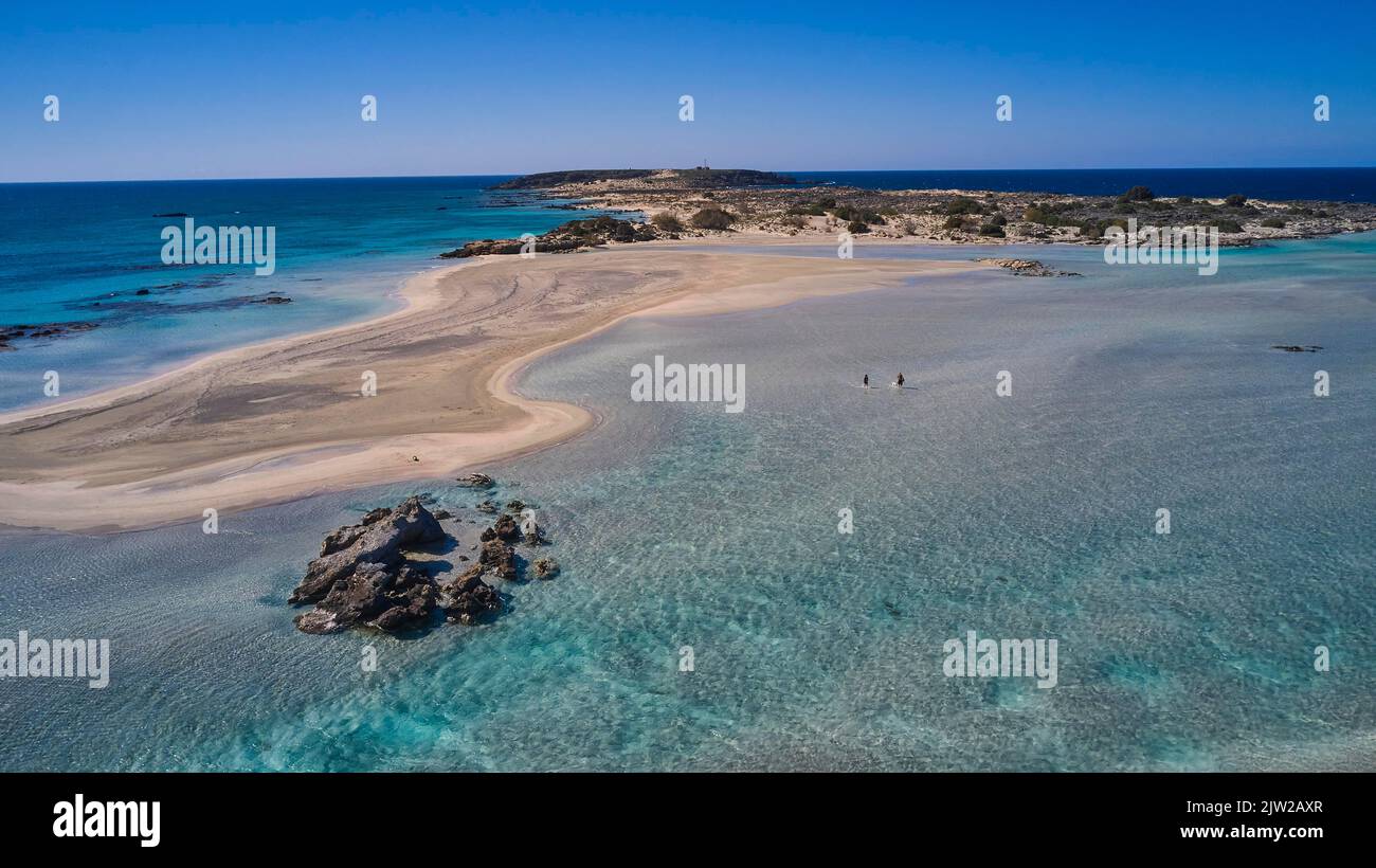 Fucilato, acque poco profonde della laguna, sandbank, due turisti in mare, cielo azzurro nuvoloso, isolotto roccioso, turchese del mare, verde mare, spiaggia di Foto Stock