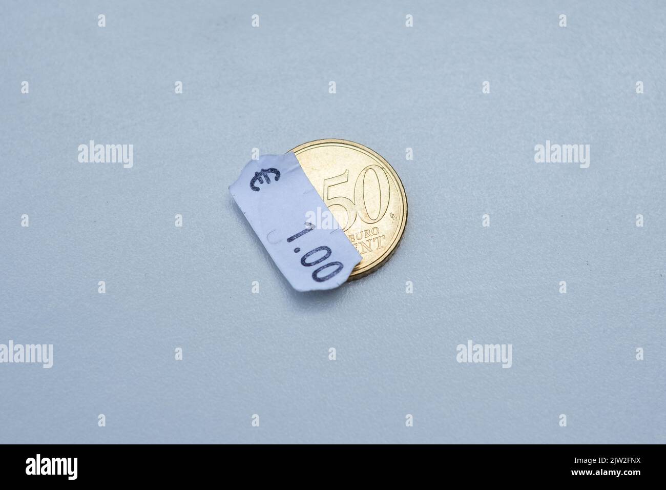 moneta da 50 centesimi di euro con un cartellino in euro. Attenzione selettiva all'etichetta. Inflazione in Europa, iperinflazione. Foto Stock