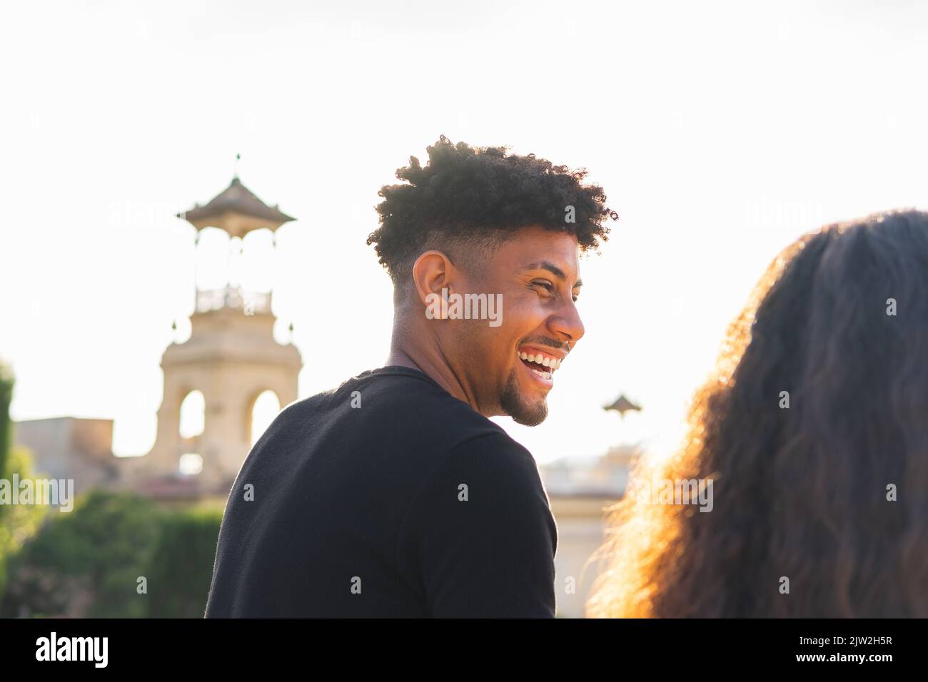 Vista laterale di una coppia multirazziale sorridente che guarda lontano Foto Stock