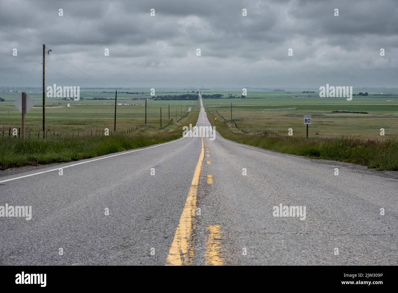 Strada diritta nelle vaste pianure di Alberta in Canada Foto Stock