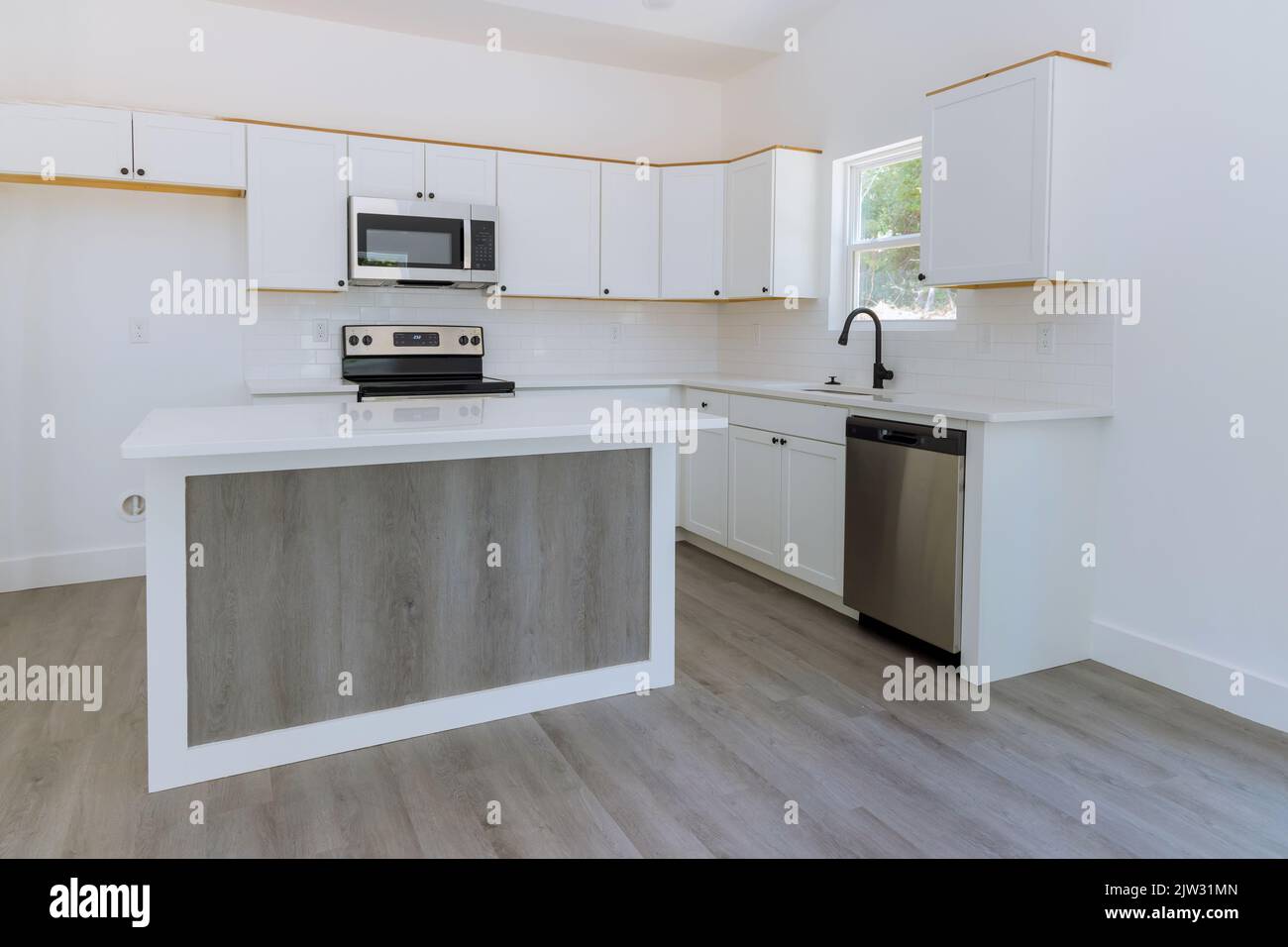 Mobili bianchi da cucina in legno con vista di miglioramento della casa installato in un set di mobili Foto Stock