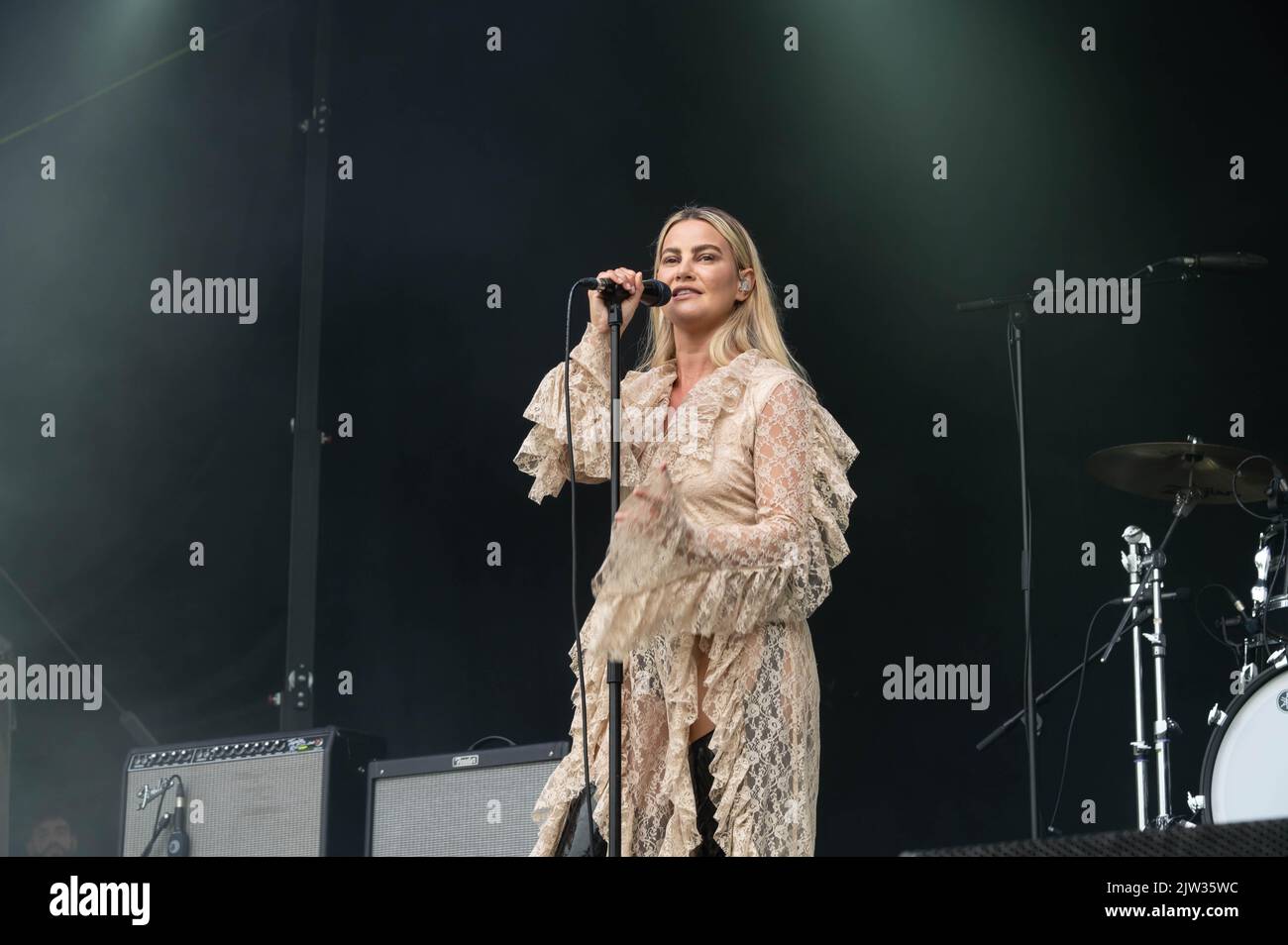 Lyra - cantando al pubblico CONNECT indossando una blusa in pizzo e stivali neri alti al ginocchio Foto Stock
