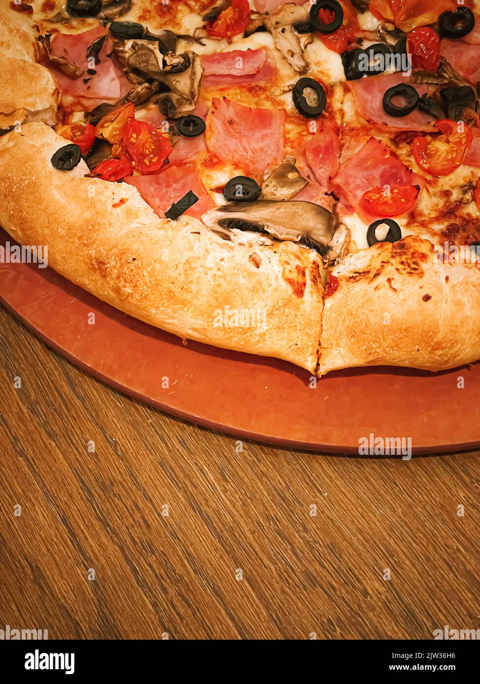 Pizza capriciosa con crosta di formaggio farcito in pizzeria, primo piano Foto Stock