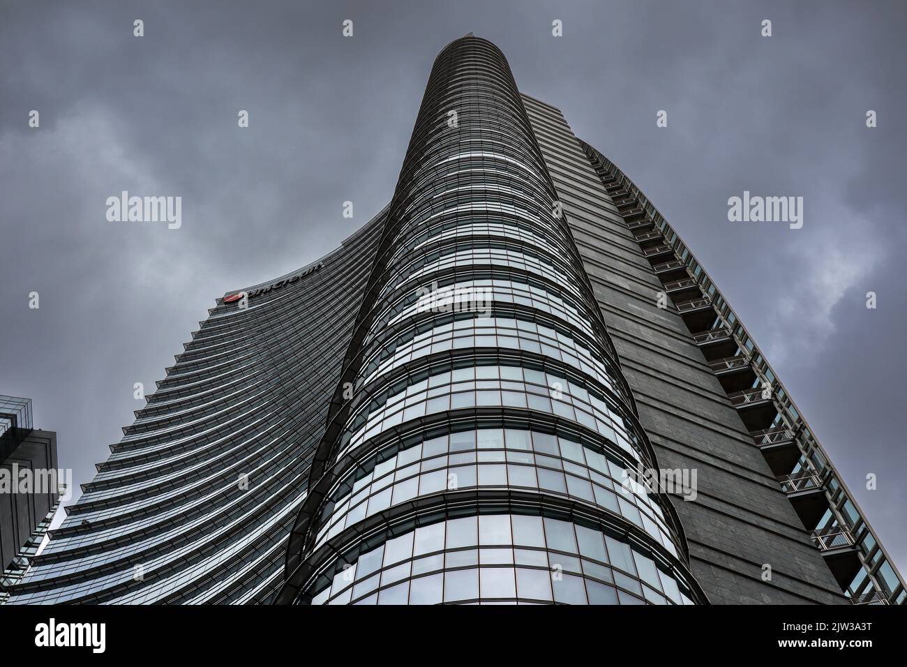Milano, Italia - 26 giugno 2022: Vista dal basso del Glass Skyscraper nel quartiere di porta Nuova. Architettura moderna di UniCredit Tower con cielo nuvoloso. Foto Stock