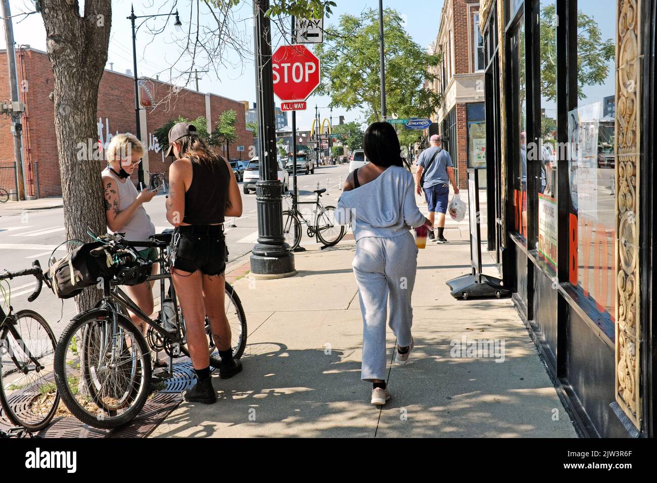 Gente sul marciapiede durante l'estate nel quartiere di Andersonville a Chicago, Illinois, Stati Uniti. Foto Stock