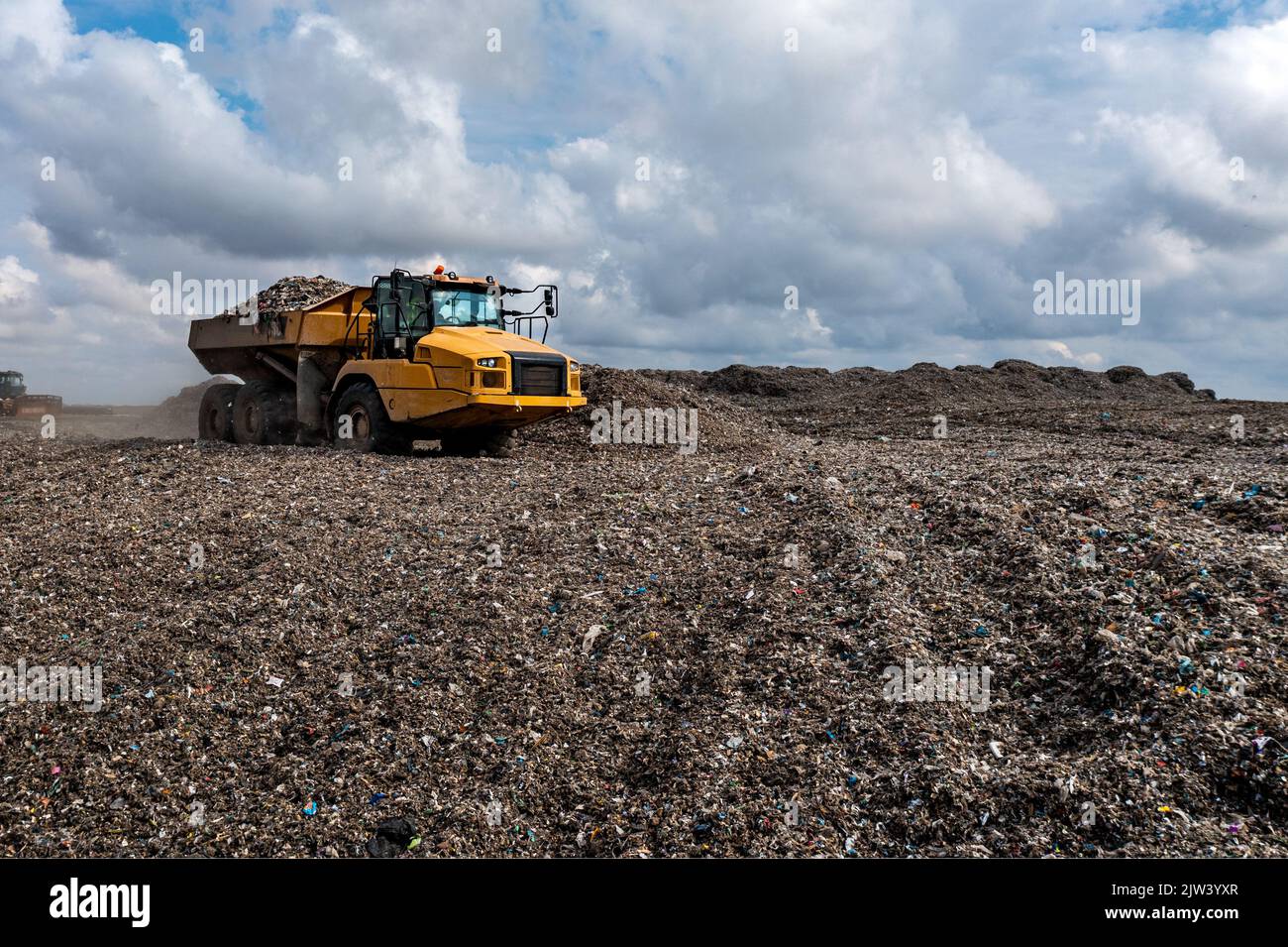 Un camion dumper su un grande sito di gestione dei rifiuti discarica scarico rifiuti in un'immagine di problema ambientale Foto Stock
