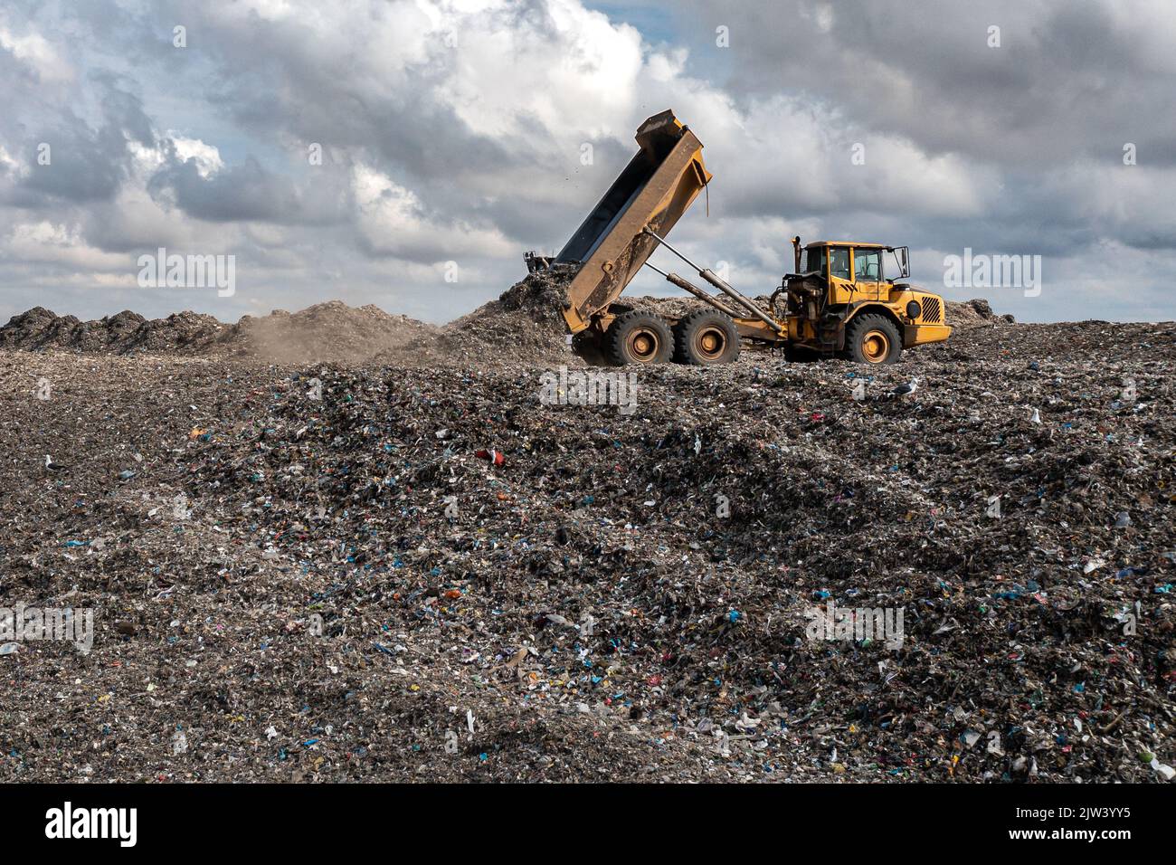 Un camion dumper su un grande sito di gestione dei rifiuti discarica scarico rifiuti in un'immagine di problema ambientale Foto Stock