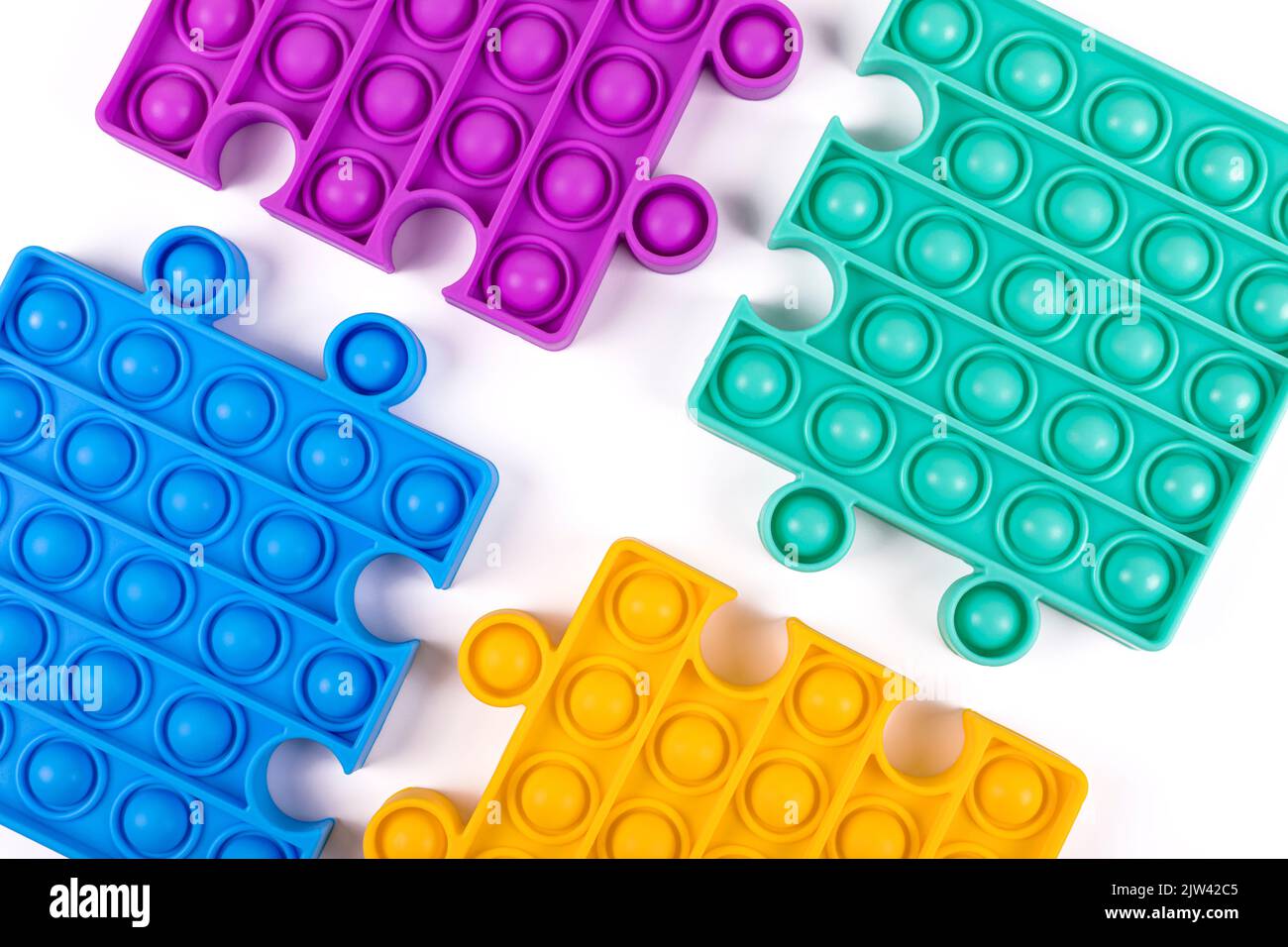 Set di famosi giocattoli colorati fidget pop su sfondo blu. Nuovi giocattoli antistress sensoriali per bambini e adulti. Giocattoli a bolle di spinta alla moda. Giacitura piatta. Foto Stock