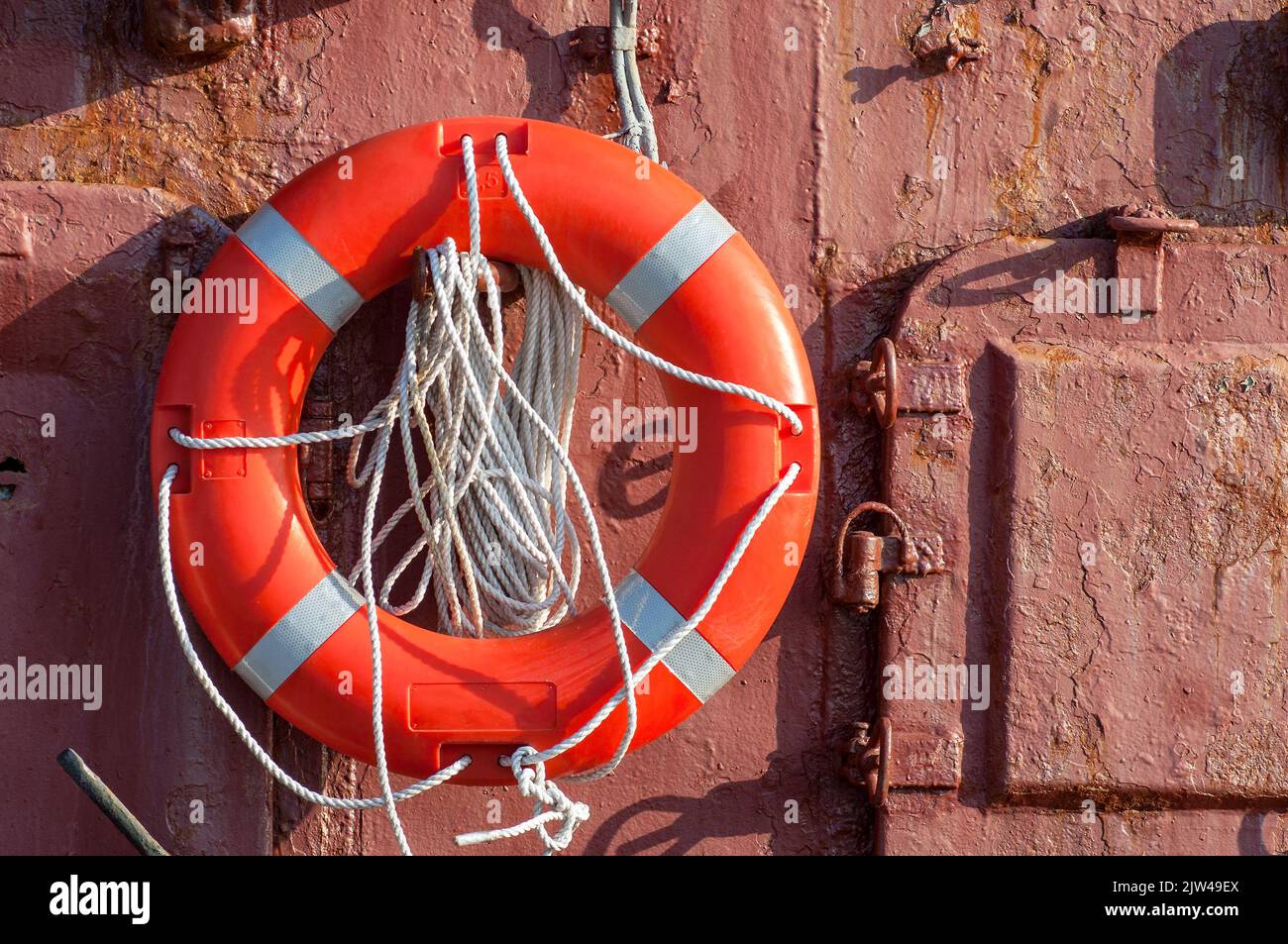 La salvaduoy con corda è appesa su una parete metallica sulla nave. Foto Stock