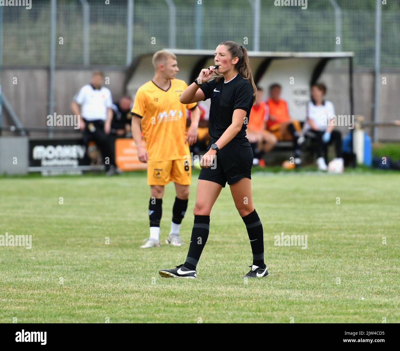 Arbitro femminile che officia alla partita di calcio semiprofessionale tra New Mills ed Eccleshall. Foto Stock