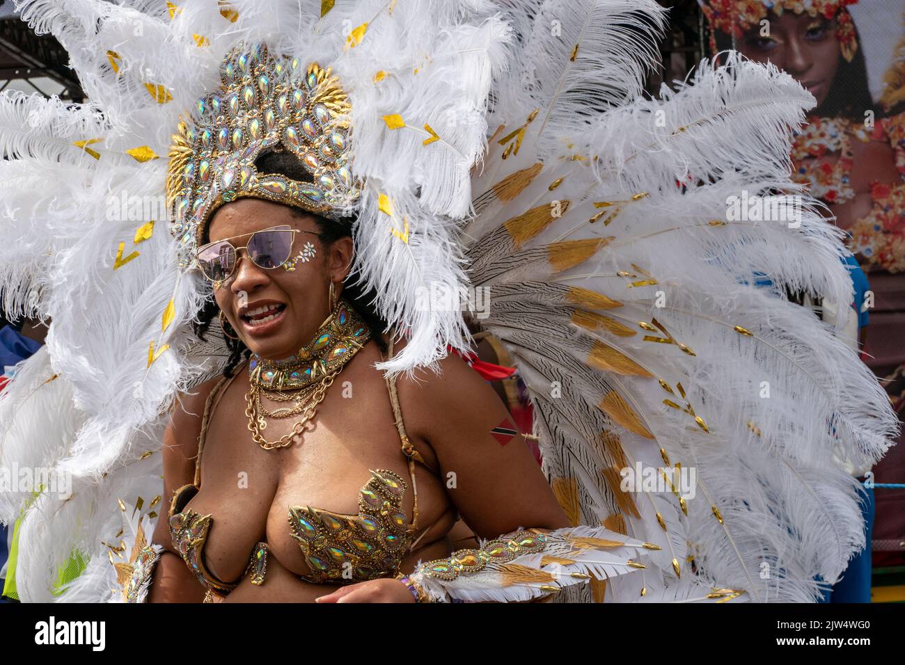 Londra, Inghilterra, Regno Unito - 29 agosto 2022: Giovane bella donna vestita per carnevale con piume bianche, a Notting Hill Gate Foto Stock