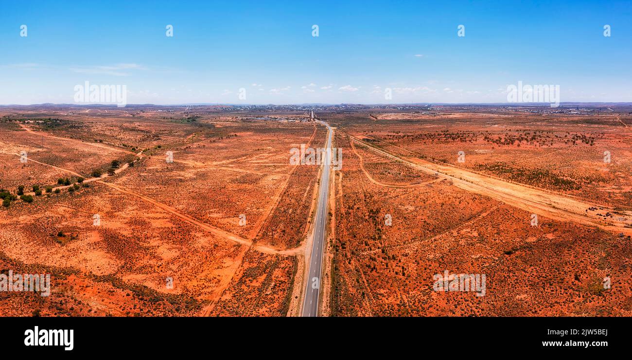 Dall'autostrada di Silver City alla città di Broken Hill attraverso l'entroterra australiano del suolo rosso in un breve panorama aereo Foto Stock