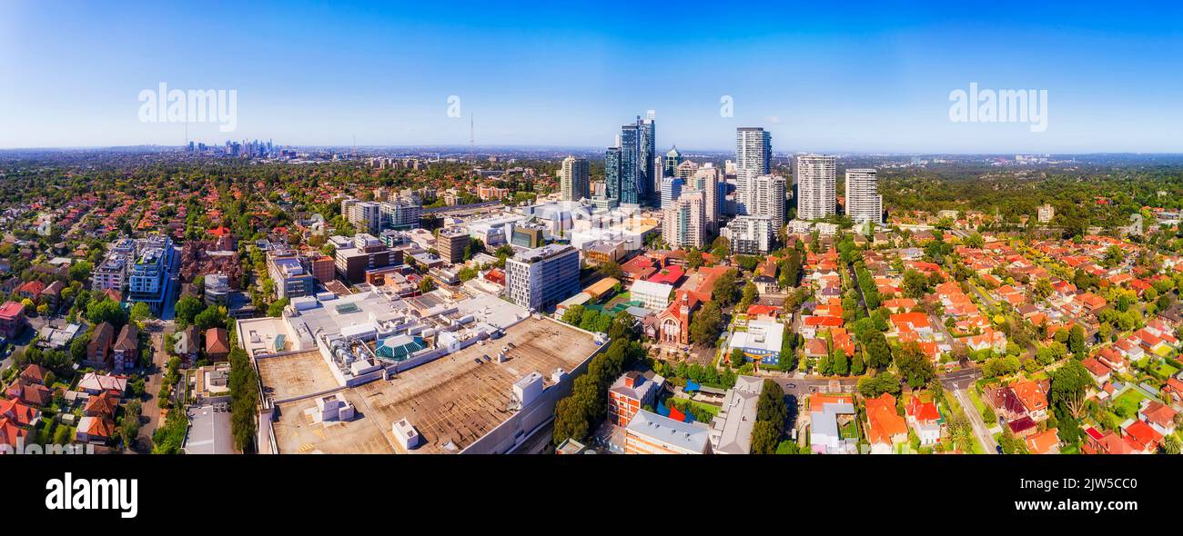 Quartiere degli affari di Chatswood con enormi centri commerciali sulla sponda inferiore nord di Sydney, in un panorama aereo dal paesaggio urbano al lontano skyline del CBD della città. Foto Stock