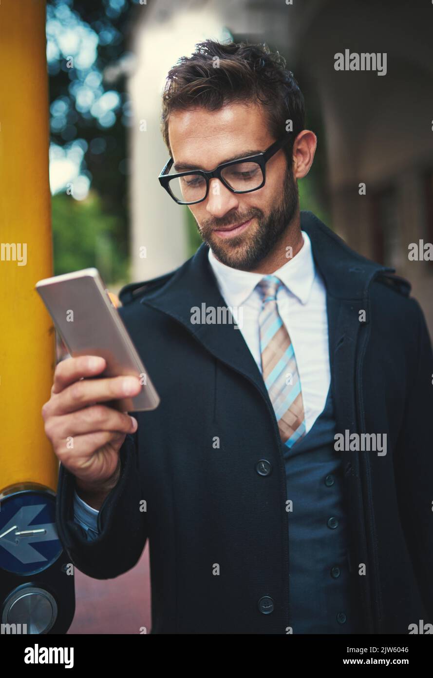 Un uomo elegante che usa il suo telefono in città. Foto Stock