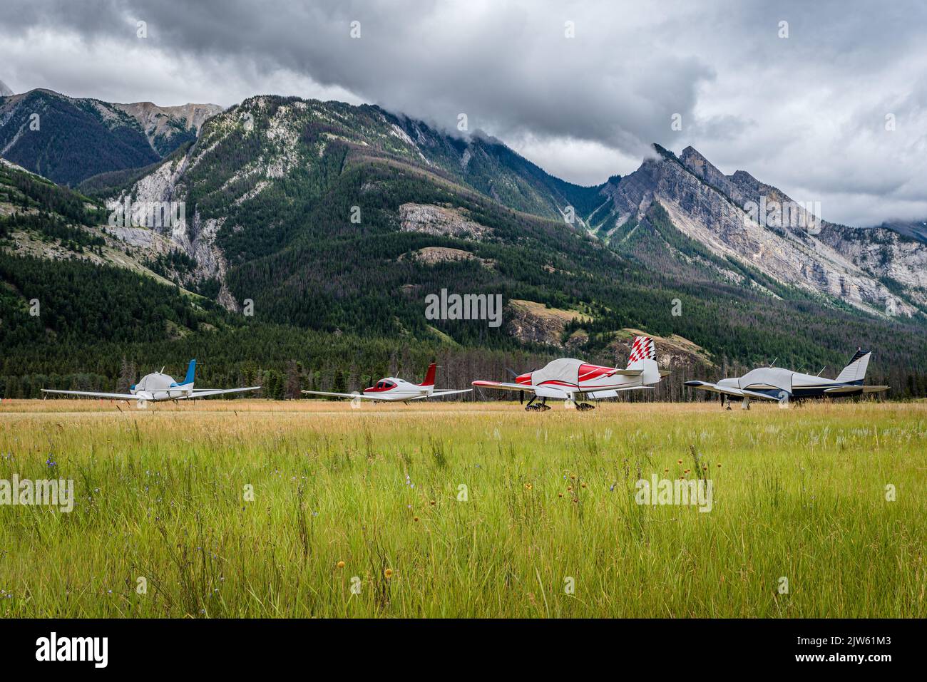 Quattro aeroplani sono legati alla Jasper Airstrip vicino a Jasper, Alberta, con le montagne sullo sfondo Foto Stock