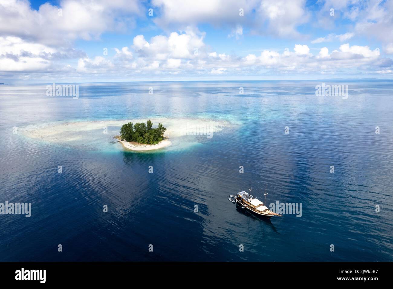 Veduta aerea di una piccola isola di corallo con Coralia barca dal vivo, Raja Ampat Indonesia. Foto Stock