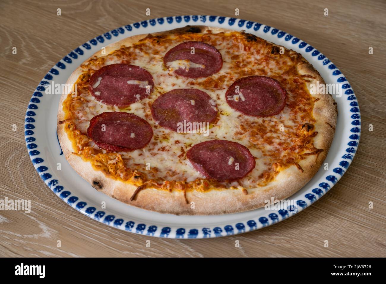 Pizza salame in stile italiano su un piatto rotondo Foto Stock