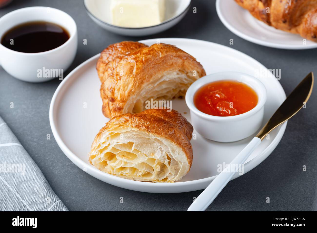 Croissant francese appena sfornato, burro e marmellata Foto Stock