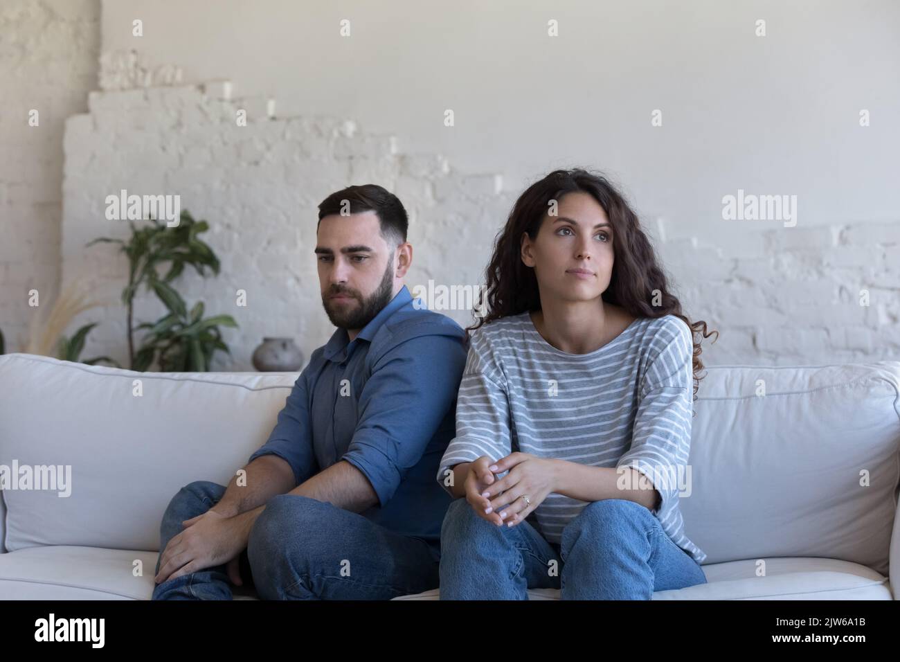 Coppia silenziosa seduta sul divano fissando da parte dopo la lotta Foto Stock