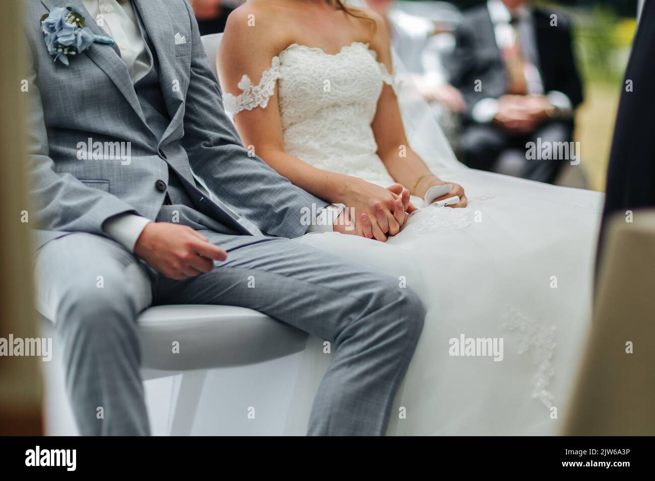 Sposa e Groom che tengono le mani durante la loro cerimonia nuziale Foto Stock