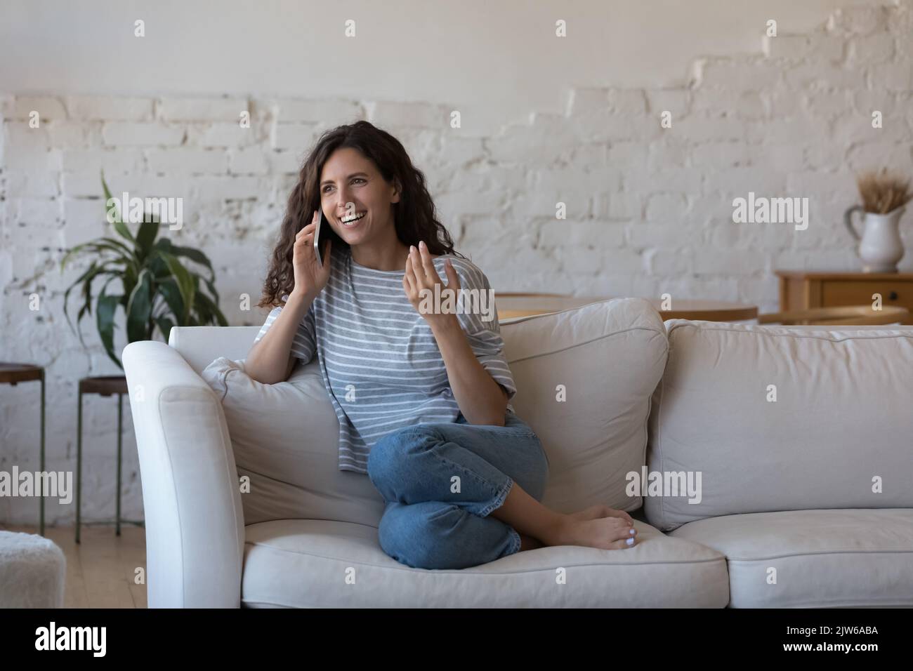 Bella donna ispanica coinvolti in una piacevole conversazione sul telefono cellulare Foto Stock