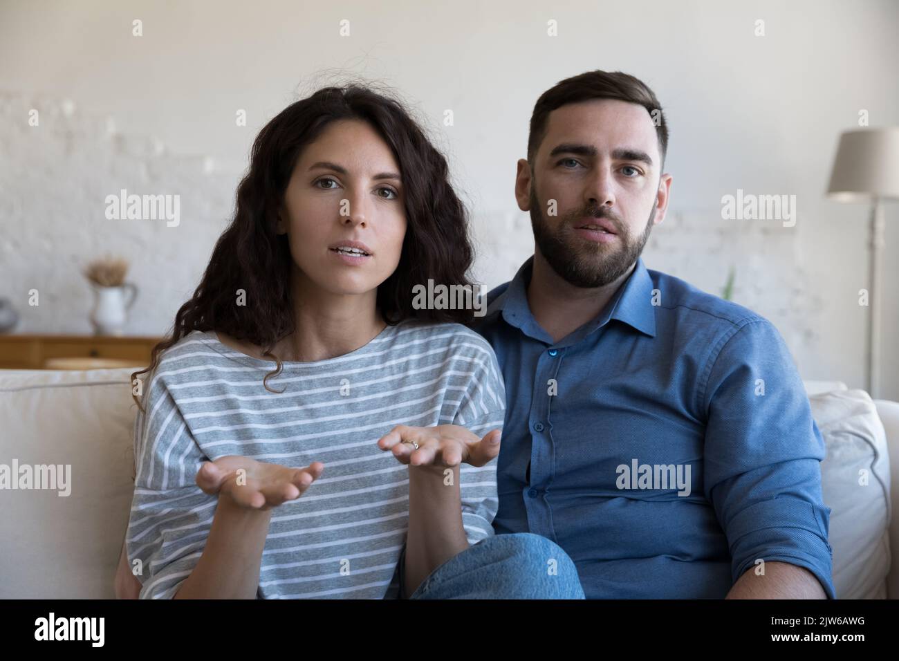 Una coppia seria guarda la telecamera mentre ha una conversazione in videochiamata Foto Stock