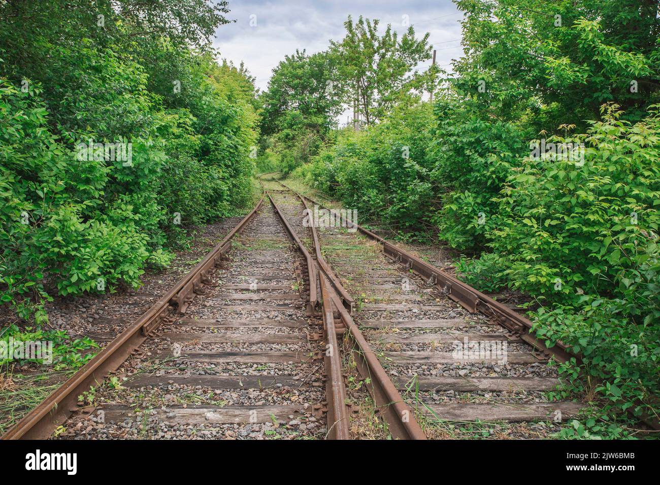 Ferrovie arrugginite abbandonate su traversine ferroviarie in legno marcio Foto Stock