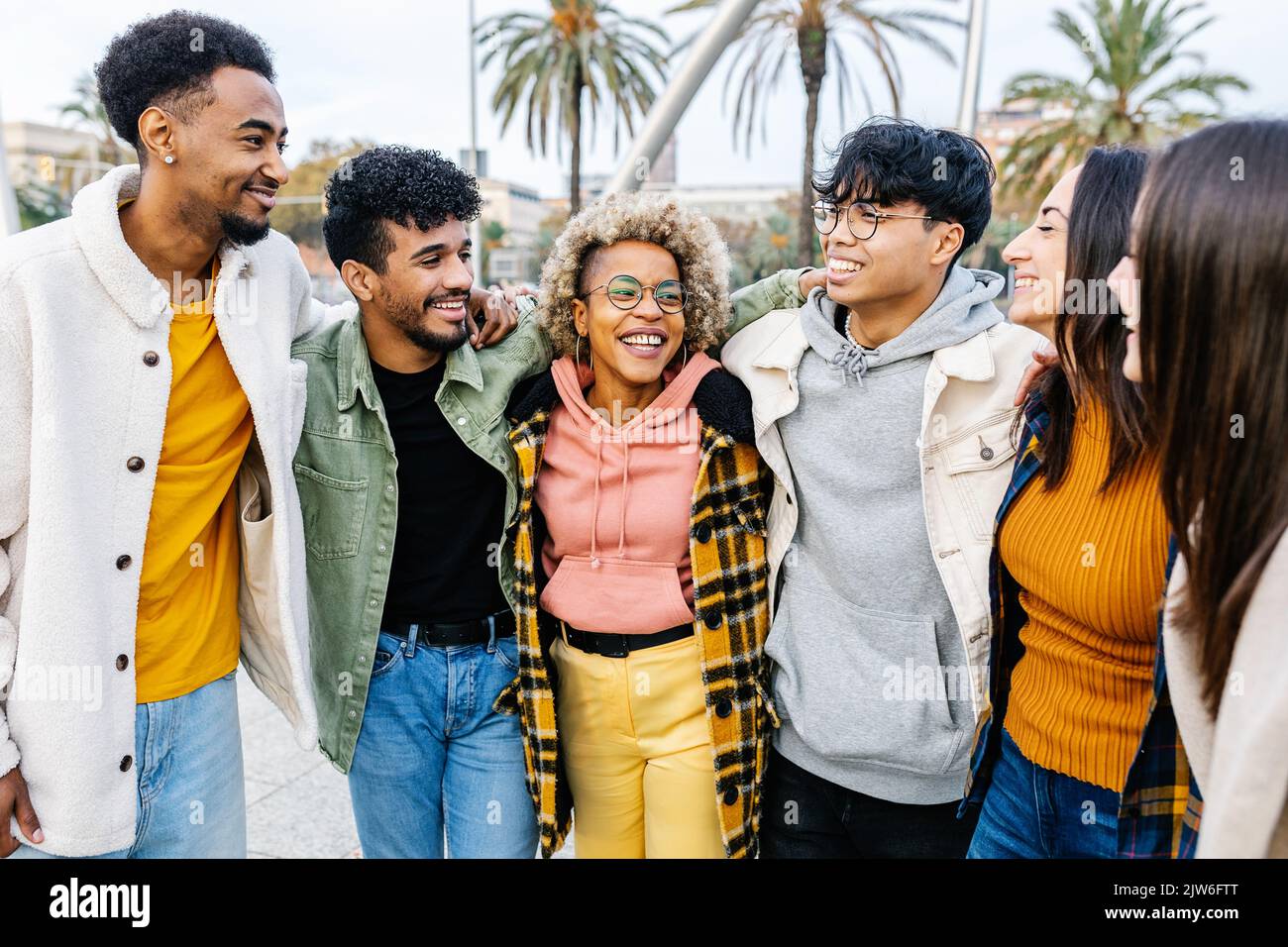 Giovane gruppo di persone multirazziali che si abbracciano all'aperto Foto Stock