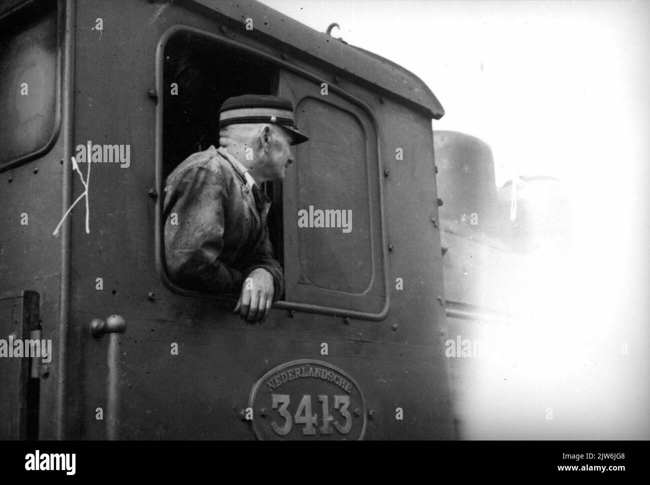 Immagine di un conducente nella casa di guida della locomotiva a vapore n. 3413 (serie 3400) del N.S. Foto Stock