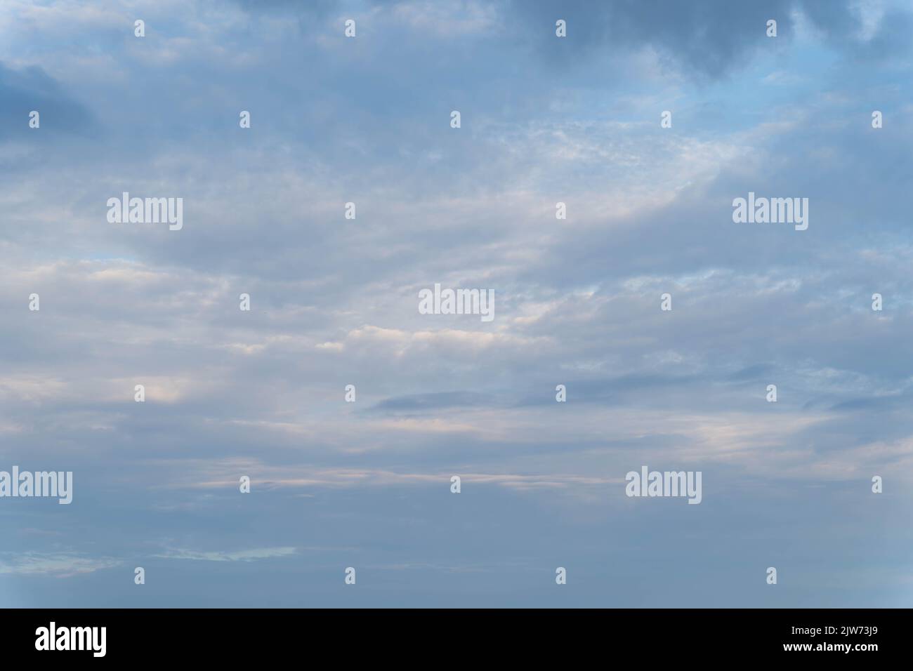 Morbide nuvole blu e grigie sparse nel tranquillo cielo estivo nel Dorset Foto Stock