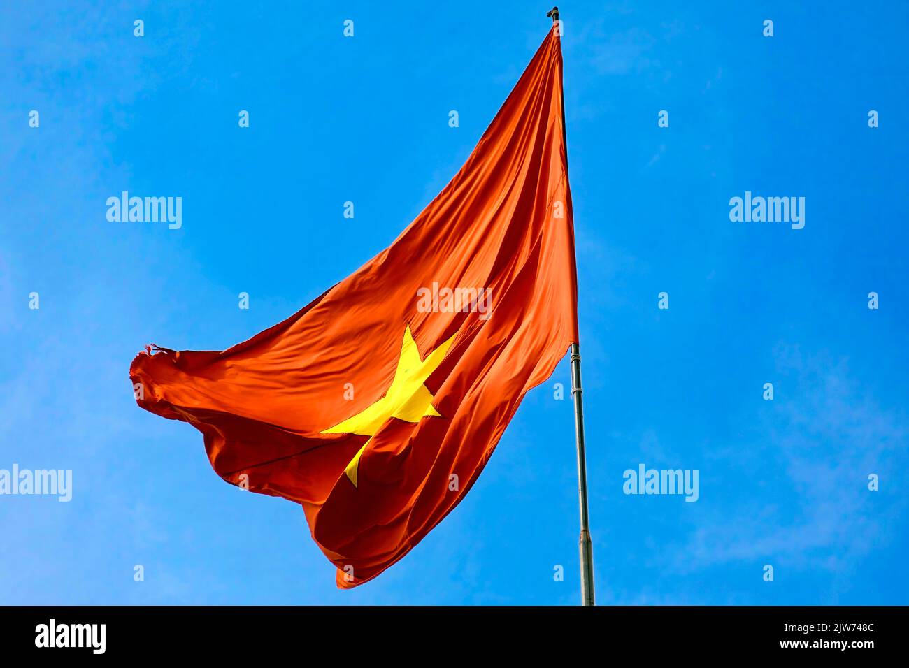Bandiera vietnamita che vola contro il cielo blu, Vietnam Foto Stock