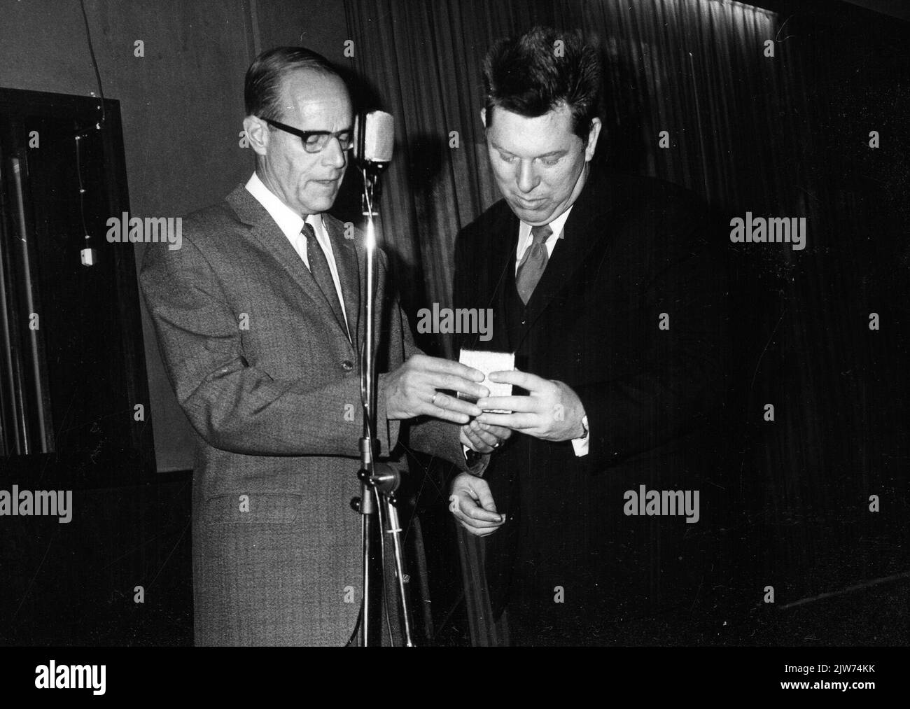 Immagine dell'offerta di una medaglia d'argento per le gambe di ir. J. Slinkers (chef del centro distrettuale del servizio di funzionamento del N.S.) al Sindaco C.F. Pouw (a destra) di Wehl in occasione dell'apertura del nuovo edificio della stazione N.S. di Wehl a Wehl. Foto Stock