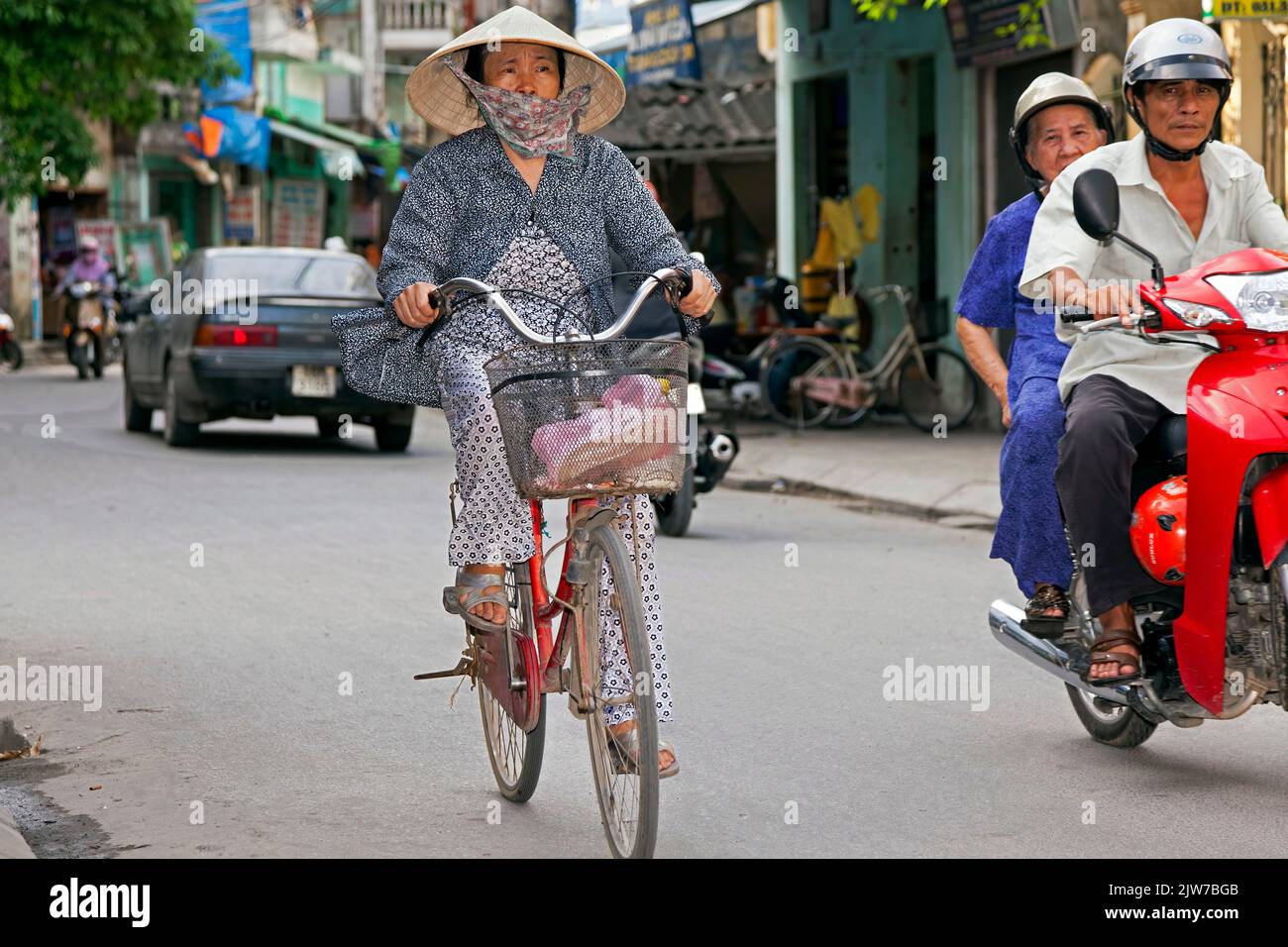 Vecchia signora che indossa un cappello di bambù in bicicletta, Hai Phong, Vietnam Foto Stock
