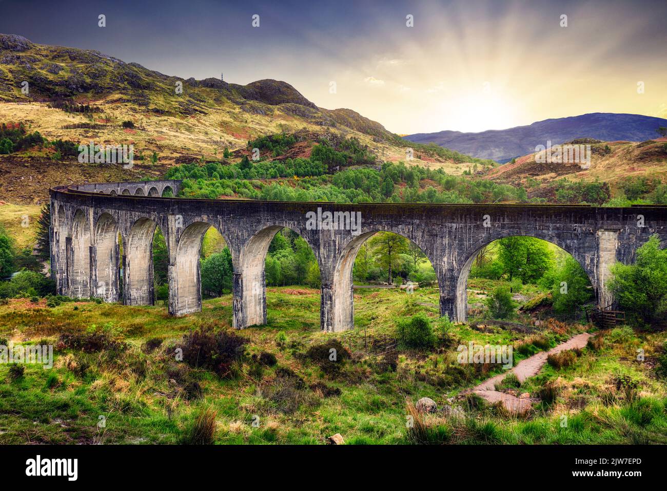 Paesaggio scozzese - Viadotto treno Glenfinnan al tramonto drammatico con sole, Regno Unito Foto Stock