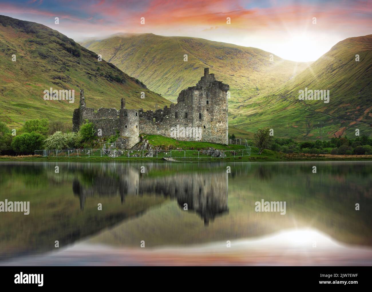 Paesaggio scozzese - Castello di Kilchurn con riflessione in acqua al tramonto drammatico Foto Stock