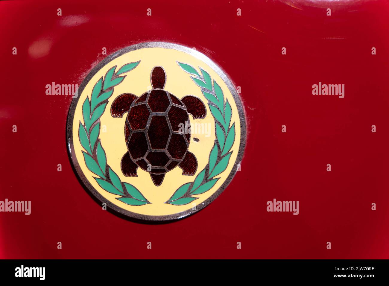 Emblema circolare con motivo a forma di tartaruga e corona di alloro su sfondo rosso Foto Stock