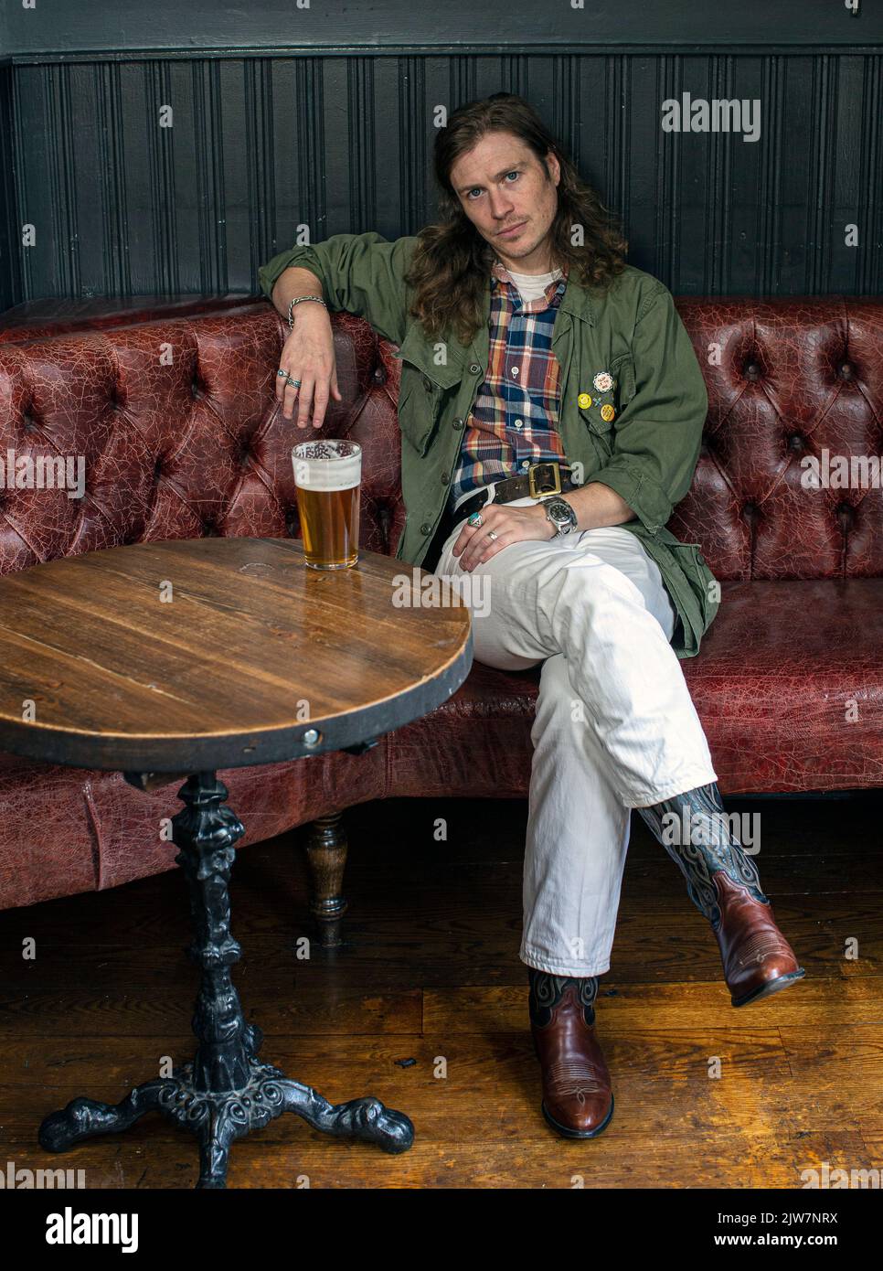 Un uomo Soho alla moda che si diverte con una pinta di lager al pub Dog and Duck di Londra, Regno Unito. Foto Stock
