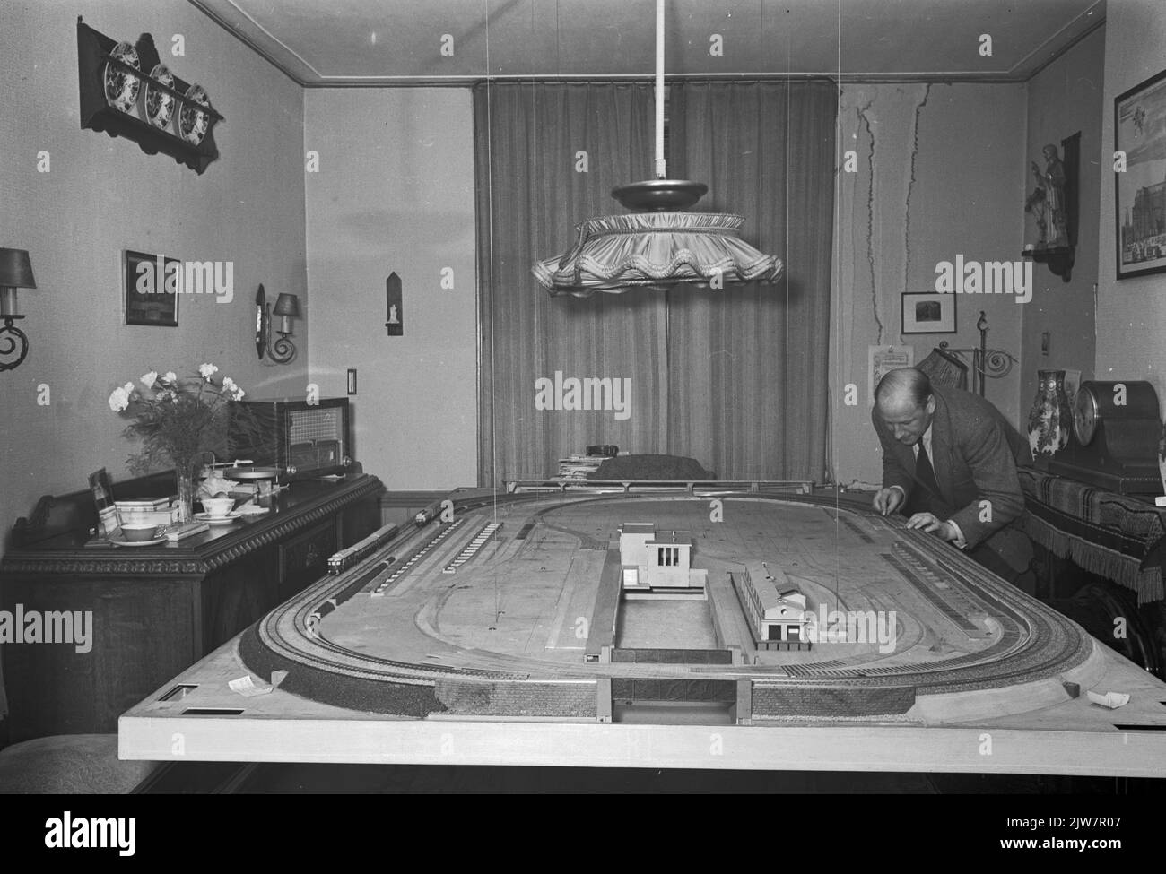 Immagine del signor H. de Groot alla sua ferrovia modello nel soggiorno della sua casa su Justus van Effenstraat in Utrecht.n.b. Vedi anche New Slower, novembre 1955, pp. 30-31: 'È in aria con il costruttore di modelli De Groot'. Foto Stock