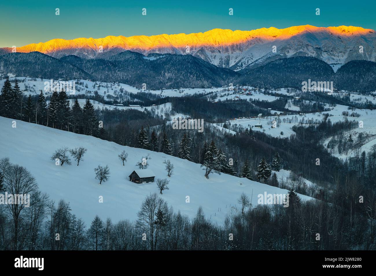 Spettacolare paesaggio invernale con alte montagne innevate. Maestosa alba e cresta innevata sullo sfondo, Piatra Craiului montagne, Carpath Foto Stock