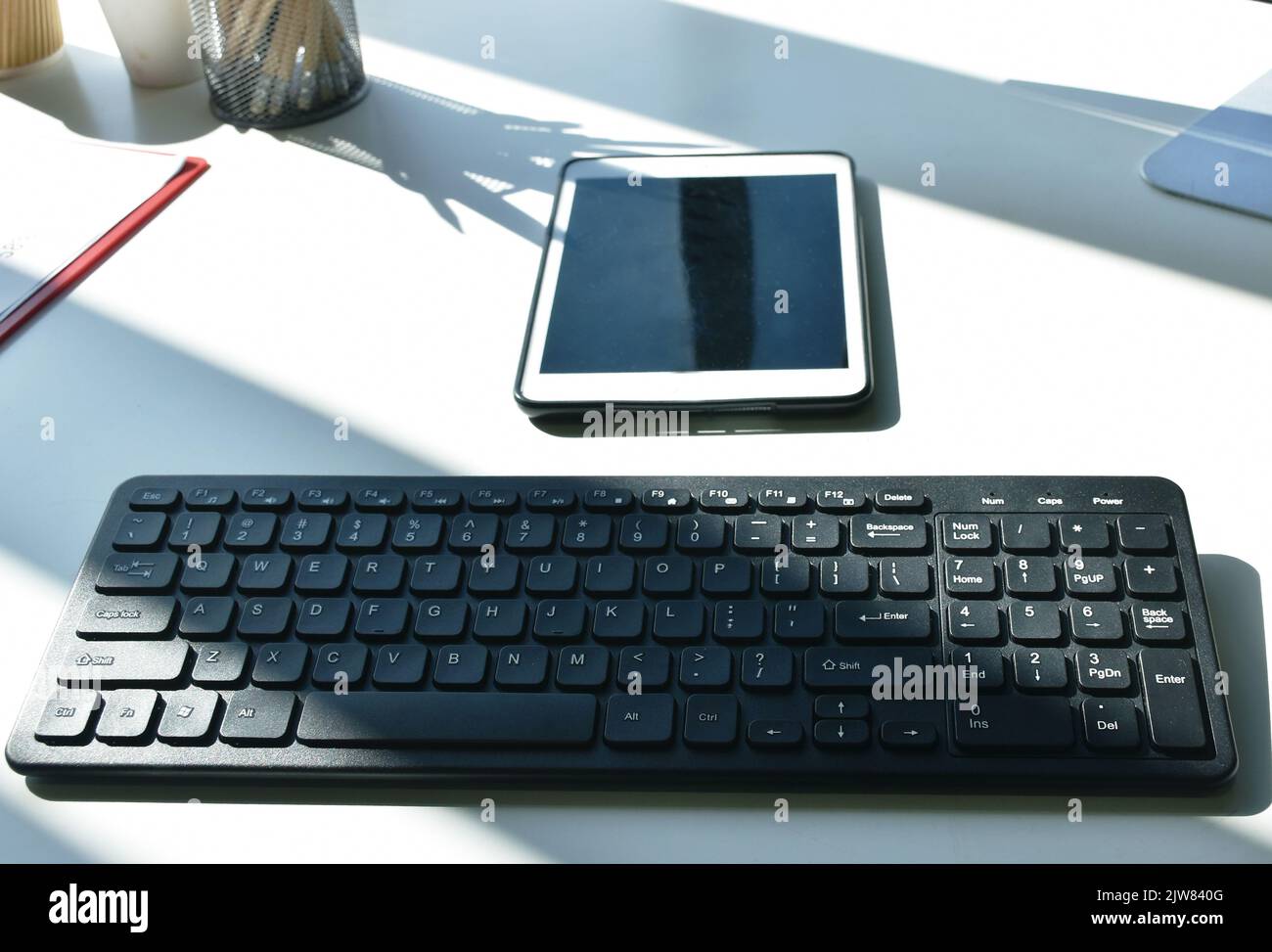 tastiera per computer e telefono cellulare sulla scrivania in ufficio Foto Stock