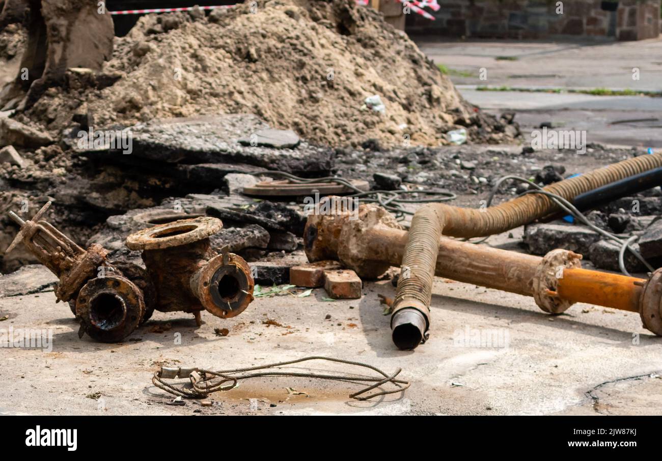 Vecchi tubi dell'acqua arrugginiti in fase di ristrutturazione sulla strada cittadina Foto Stock