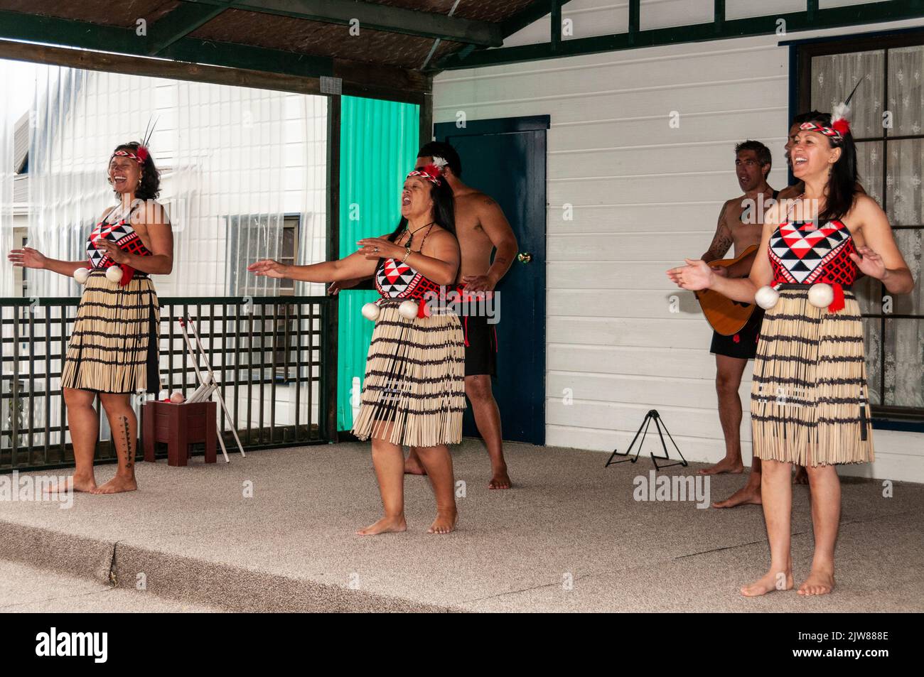 Un gruppo di donne Maori che si esibiscono in un concerto culturale per turisti in visita presso l'unico villaggio Maori della Nuova Zelanda, situato all'interno della geotermia Foto Stock