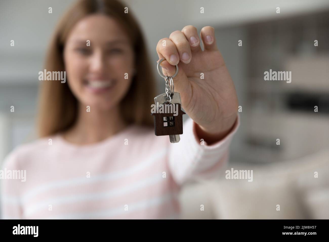 Donna acquirente casa felice tenendo le chiavi alla macchina fotografica Foto Stock