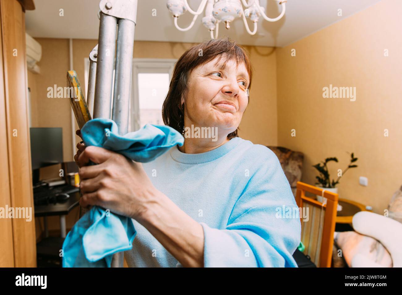 Felice timido Donna matura appartamento di pulizia. Concetto di casa e persone in pensione. Donna anziana pulizia Appartamento. Concetto di Senior attivo Foto Stock