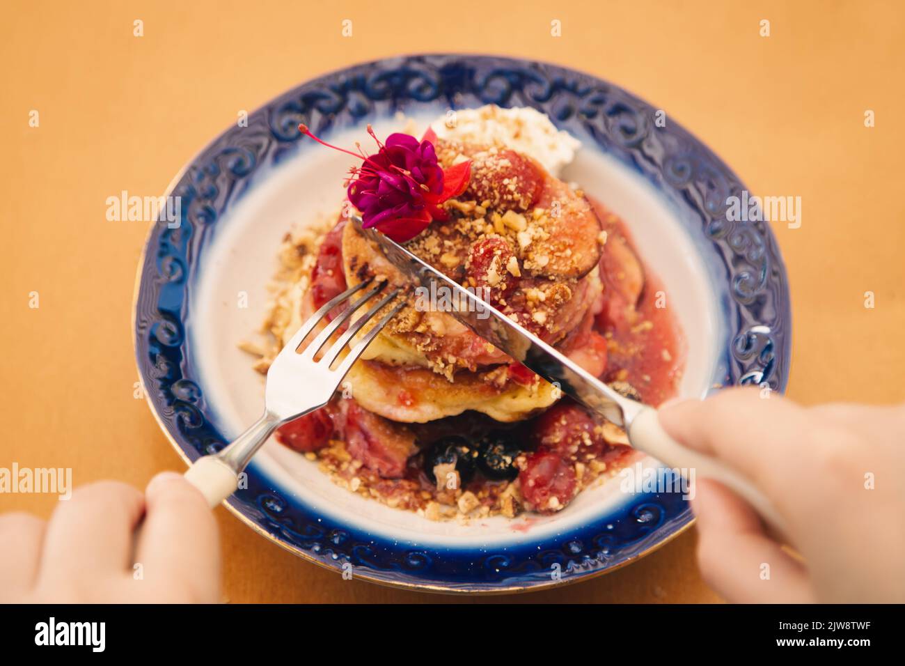 Appetitose frittelle decorate con frutti di bosco e fiori. Foto Stock