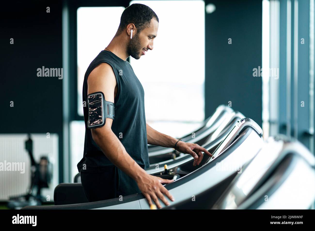Allenamento sportivo muscoloso afro-americano su tapis roulant in palestra Foto Stock