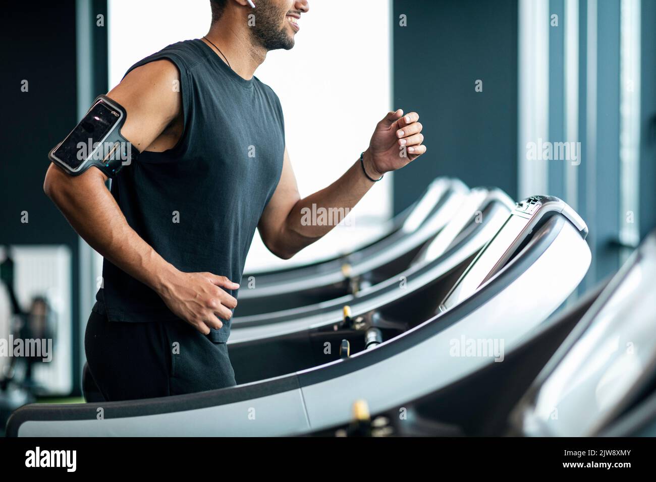 Corto di sorridente Black Man in Sportswear jogging sul tapis roulant alla palestra Foto Stock